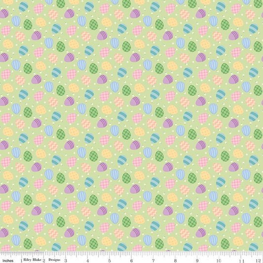 Patterned fabric with Easter eggs and flowers on a green background
