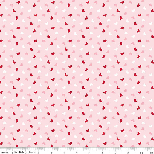 Pattern of small red and pink hearts on a light pink background with a ruler at the bottom.