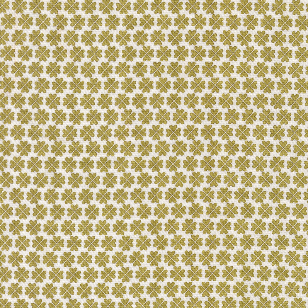 Pattern of green four-leaf clovers on a beige background